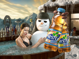 Attractive woman and the Nestea snowman sitting in a hot tub in snowy mountains